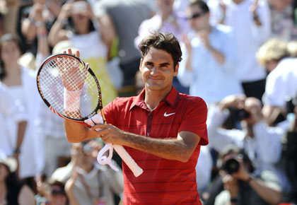 Switzerland's Roger Federer celebrates after winning against Switzerland's Stanislas Wawrinka during their men's fourth round match in the French Open tennis championship at the Roland Garros stadium, on May 29, 2011, in Paris.  AFP PHOTO / MIGUEL MEDINA (